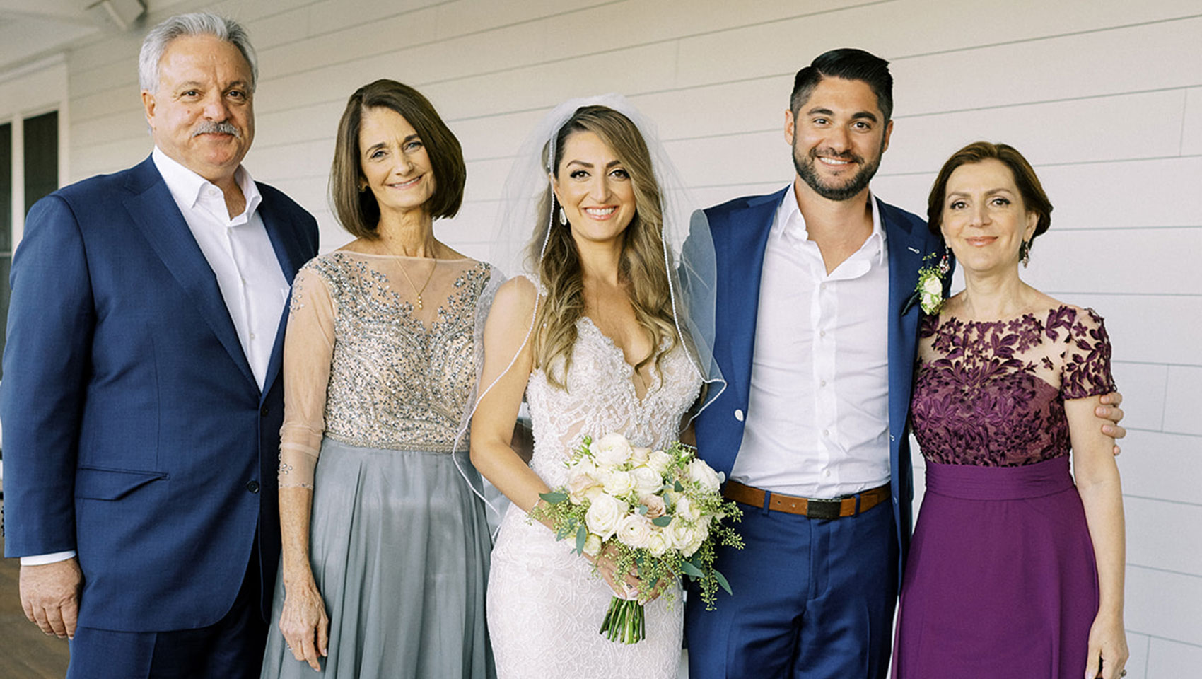 Bride and groom posing with family members