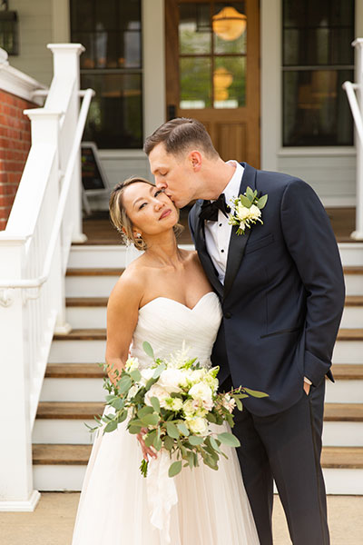 Groom kissing bride in front of Kimpton Taconic Hotel entrance