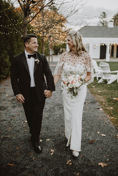 Bride and Groom looking at each other and walking down outdoor path