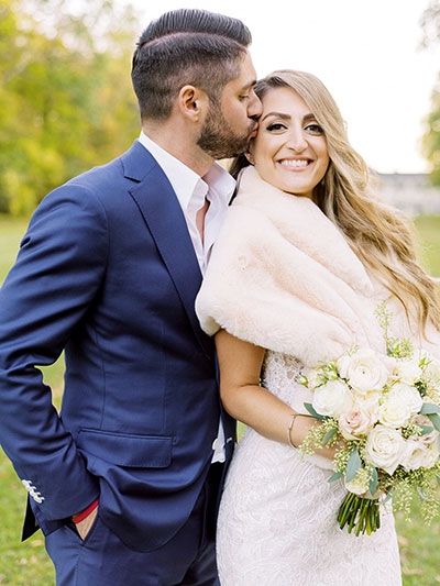 Groom kissing bride’s forehead 